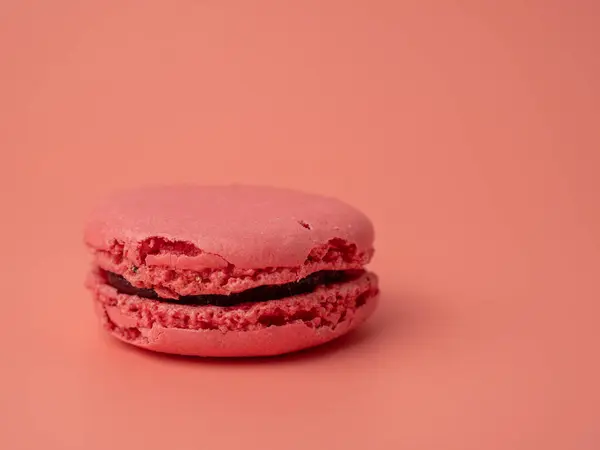 Colorful French macaroons on a pink background. French macaroons close-up.