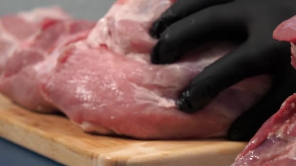 Ένας Άντρας Μαύρα Γάντια Κόβει Χοιρινό Κρέας Ένα Ξύλο Κοπής — Αρχείο Βίντεο