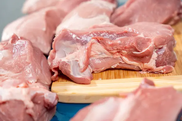 Pork meat cut into pieces lies on a cutting board. Pork meat close-up.