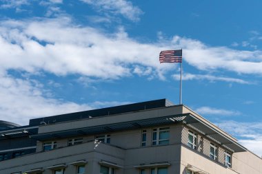 Mavi gökyüzüne Amerikan bayrağı sallıyor. Binanın çatısında Amerikan bayrağı.