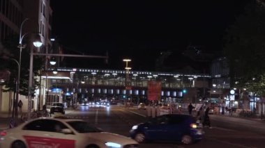 Berlin, Almanya, Mayıs 05, 2024. Geceleri arka planda büyük bir bina olan işlek şehir zooloji bahçesi. Sokaklar araba ve insanlarla dolu. Birkaç trafik ışığı var. Sahne canlı ve canlı.. 