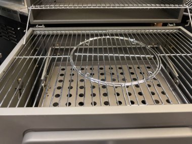 Üstünde metal bir sepet olan ızgara. Izgara gümüş renginde ve siyah saplı.