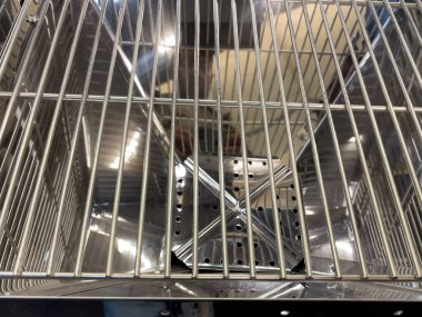 Ortasında ağ sepeti olan bir ızgara. Izgara gümüş renginde ve parlak bir görünüşü var.