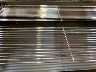 Bir sürü metal çubuğu ve parlak yüzeyi olan bir ızgara.