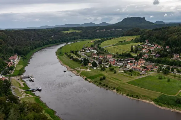 stock image A river runs through a town with houses and a bridge