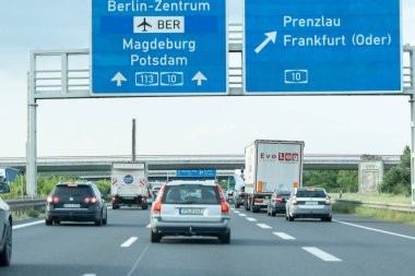 Almanya, 17 Mayıs 2024. Üzerinde Berlin-Zentrum yazan mavi tabelası olan bir otoyol. Yolda bir kamyon da dahil olmak üzere bir sürü araba var..