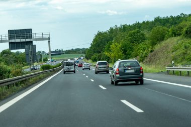 Almanya, 17 Mayıs 2024. Bir sürü arabası olan yoğun bir otoyol. Arabalar orta hızda hareket eder. Otoyol arka planda ağaçlarla çevrili..