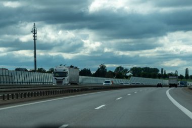 Almanya 17 Mayıs 2024. Ortasında bir kamyon olan uzun bir otoyol. Gökyüzü bulutlu ve yol boş..