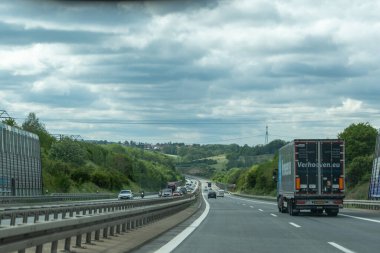 Almanya 17 Mayıs 2024. Ortasında kamyon olan uzun bir otoyol. Kamyon siyah beyaz. Gökyüzü bulutlu..