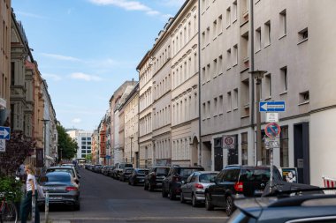 Almanya 17 Mayıs 2024 Birçok aracın park ettiği bir cadde. Sokak binalarla dolu ve tabelada mavi bir ok var..