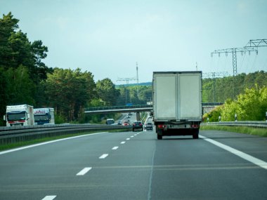 Almanya, 17 Mayıs 2024. Arka planda köprü olan bir kamyon otoyol boyunca gidiyor. Yoldaki tek araç kamyon değil.