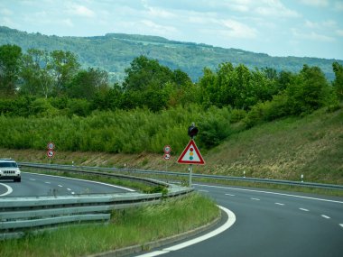 Almanya 17 Mayıs 2024 Sarı ve kırmızı tabelası olan bir yol ve yoldan geçen bir araba.