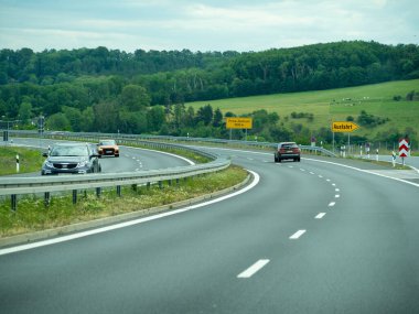 Almanya 17 Mayıs 2024 Sarı tabelası olan bir araba yolda ilerliyor. Yolda başka arabalar da var.