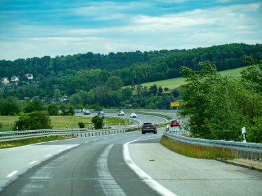 Almanya 17 Mayıs 2024 Üzerinde bir sürü araba olan bir otoyol. Arabaların çoğu kırmızı ve beyaz. Yol çok geniş ve ön planda hiç ağaç yok.