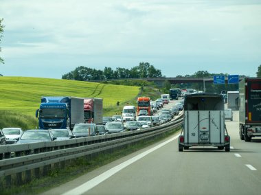 Almanya 17 Mayıs 2024 Yol kenarında karavanı olan yoğun bir otoyol. Kamyonla çekilen bir karavan.