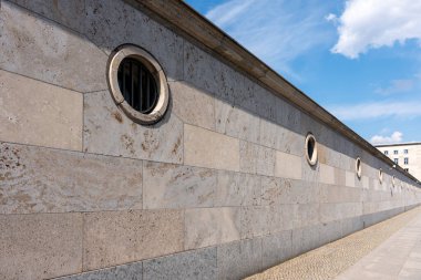 Yuvarlak pencereli mermer duvar. Pencereleri ve tuğlaları olan bir duvar.