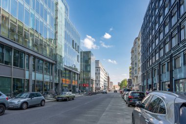 Almanya, 7 Haziran 2024. Bir sürü arabası ve birkaç yayası olan işlek bir şehir caddesi. Binalar yüksek ve gökyüzü temiz.