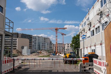 Almanya Berlin, 07 Haziran 2024. Arkasında vinç ve büyük bir bina olan bir inşaat alanı. Turuncu ve sarı.