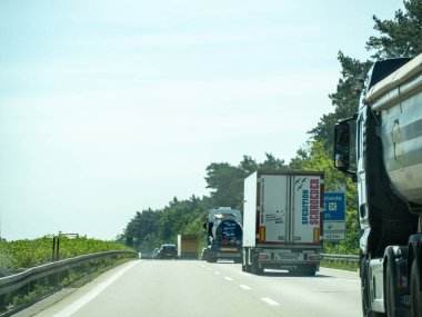 17 Mayıs 2024 'te üzerinde Schneider yazan bir kamyon otoyolda ilerliyor. Yolda başka kamyonlar ve arabalar da var.