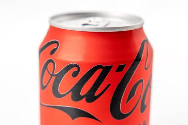 Yakın planda bir kutu Coca Cola gösteriliyor. Kutu kırmızı ve siyah. Önünde Coca Cola logosu var.