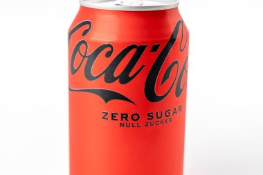 Bir kutu Coca Cola Zero Sugar. Kutu kırmızı ve siyah bir logosu var. Kutu beyaz arka planda duruyor.