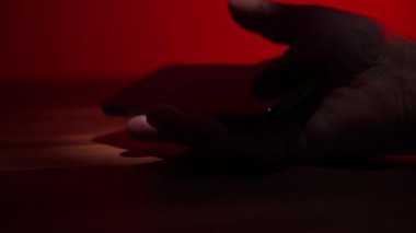 Akıllı telefonlu bir el, yanıp sönen polis ışıklarının arka planına karşı masaya düşer. Akıllı telefonlu yakın plan el..