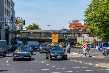 Almanya 7 Ağustos 2024. Arabaları, bisikletleri ve bisikletli bir adamı olan işlek bir cadde. Sokak Zooloji Bahçesi 'nde..