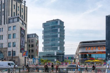 Almanya 7 Ağustos 2024. Birçok insanın yürüdüğü Warschauer Caddesi 'ndeki bina, köprü ve süpermarket. Berlin şehir trafiği.