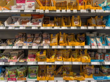 Almanya 12 Ağustos 2024. Bir sürü farklı köpek maması içeren bir mağaza rafı. Yemek kutular ve poşetlerde. Raflar dolu ve bir sürü çeşidi var.