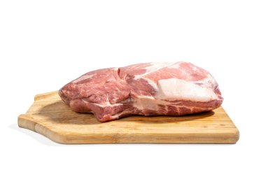 Tahta kesme tahtasının üzerinde bir parça et var. Et parçalara ayrılır ve pişirilmeye hazırdır. Beyaz arka planda izole edilmiş domuz eti..