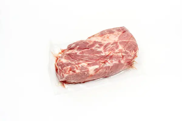 stock image A piece of meat is displayed in a plastic bag. The meat is white and pink Pork meat isolated on white background..