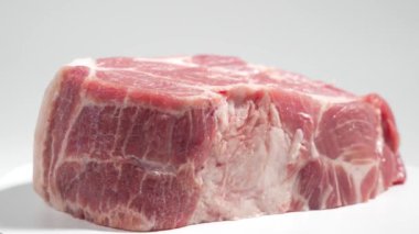 Domuz eti beyaz arka planda döner. Beyaz üzerine çiğ domuz eti..