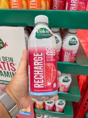 Almanya 17 Ağustos 2024. Bir kişi elinde bir şişe Volvic vitamin suyu tutuyor. Şişe pembe ve beyaz.