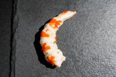 Surimi 'nin karides hali siyah bir yüzey üzerindedir. Beyaz ve kırmızı karides