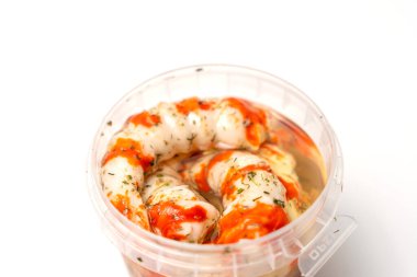 Food container with red sauce and white sauce. Container with Surimi in the form of shrimp sauce and white background clipart