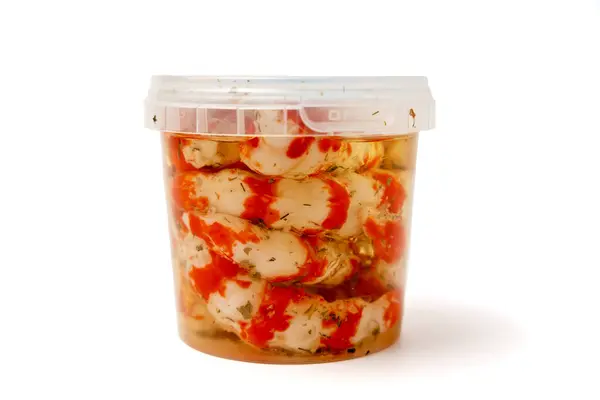 stock image Container with Surimi in the form of shrimp on a white background. The container is transparent and has a lid.