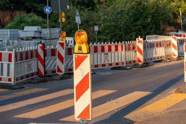 Üzerinde sarı ve kırmızı işaret olan kırmızı ve beyaz çizgili bir direk. İnşaat uyarısı işareti.