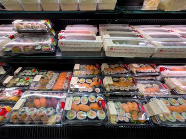 Almanya 31 Ağustos 2024. Mağazada suşi gösterisi. Suşi plastik kaplarda ve müşterilerin görmesini ve seçmesini kolaylaştıracak şekilde düzenleniyor. Sahne sıradan ve davetkar.