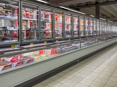 Germany Berlin August 31, 2024. Large supermarket with rows of products and a freezer. The freezer is full of frozen food.