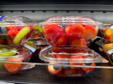 Almanya 31 Ağustos 2024. Plastik kaplarda bir sıra meyve. Meyve çoğunlukla çilektir. Konteynırlar üst üste istiflenmiş.