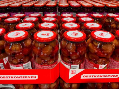 Almanya 31 Ağustos 2024. Üzerinde Obstkonserveren yazan kırmızı ve berrak çilek kavanozları. Kruvasan planlı bankalar.