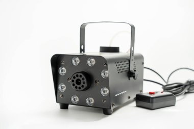 Üzerinde beyaz kablo olan siyah bir duman makinesi. Cihaz bir duman makinesi..