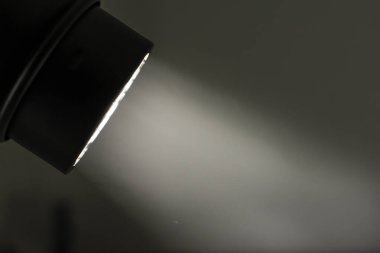 Karanlık bir odada, yönlendirilmiş bir ışık huzmesi. Işık huzmesi karanlık odada görünür..