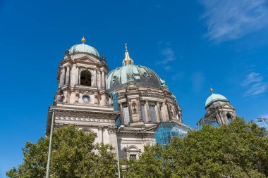 Mavi kubbeli ve iki yeşil kubbeli büyük bir kilise. Berlin Katedrali. Gökyüzü açık ve mavi