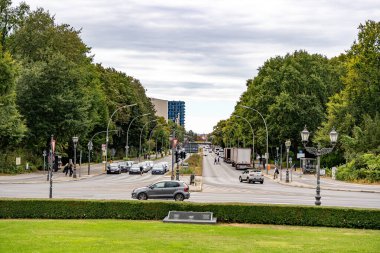 Almanya 15 Eylül 2024. Berlin 'de arabaları ve yayaları olan kalabalık bir cadde. Sokaklar ağaçlar ve parklarla çevrili..