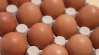 Karton bir kutuda kahverengi yumurtalar. Dönen kahverengi yumurtalar.