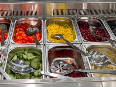 Gümüş tepside havuç, salatalık ve biber gibi çeşitli sebzeler sergilenmektedir.