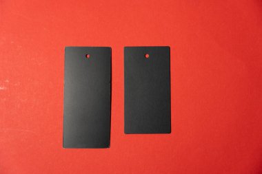 Kırmızı arka planda iki kara leke var. Etiketler şekil olarak aynı. Kırmızı arkaplan, etiketlere dikkat çekerek, parlak ve zıt bir etki yaratır.