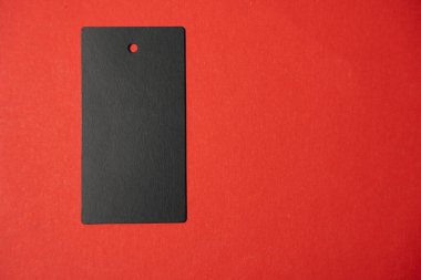 Kırmızı arka planda siyah bir etiket var. Resmin ana odak noktası kırmızı arkaplan