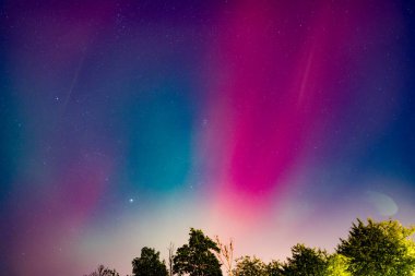 Parlak yıldızlarla dolu gece gökyüzünde çok renkli muhteşem aurora borealis. Aurora 'nın renkleri mavi, yeşil ve mor.